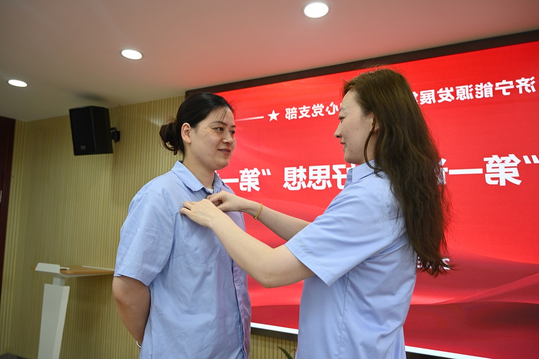 2023年7月7日，老党员张旭为新党员戴党徽（地点：正则招标1112室，拍摄人：靳溢欣） - 网站.JPG